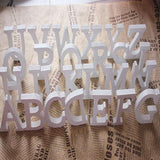 Lettre en bois blanche en position verticale